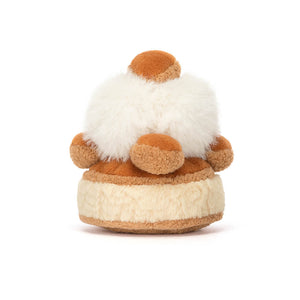 Back view of a Jellycat St. Honoré cake shaped plush on a white background. 