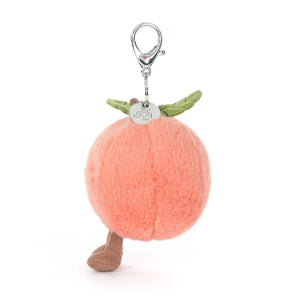 Side view of a Jellycat peach plush keychain with brown feet on a white background.