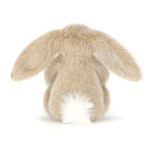 Back view of a Jellycat oat coloured bunny plush with a white fluffy tail on a white background.