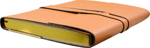 A brown vegan leather notebook with gilded gold edges lying flat on a white background.