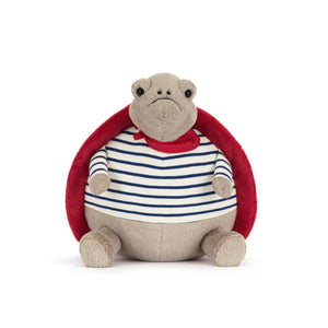 Front view of a beige Jellycat turtle plush with a frowning face wearing a blue and white striped shirt and a red shell on a white background