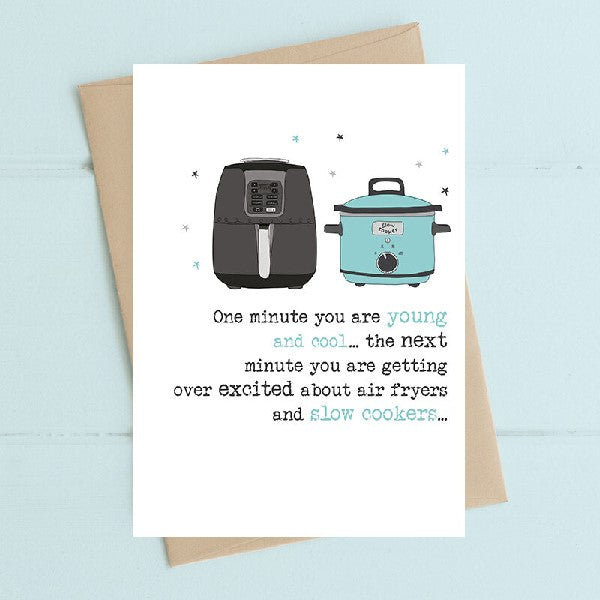 white birthday card with illustrated air fryer and light blue slow cooker. text below reads "one minute you are young and cool... the next minute you are getting over exxcited about air fryers and slow cookers..."