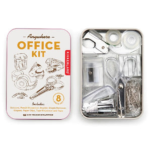 open white metal container. lid sees illustrated objects included in the kit: scissors, pencil sharpener, stapler, staple remover, staples, paper clips, tape dispenser, and tape. top text on lid reads "anywhere office kit". kikkerland product on white background