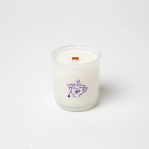 White candle with a purple mug illustration and the text 'blueberry tea' on a white background.