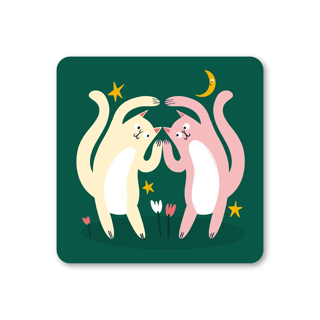 Coaster featuring an illustration of two dancing cats on a dark green background with stars and flowers.