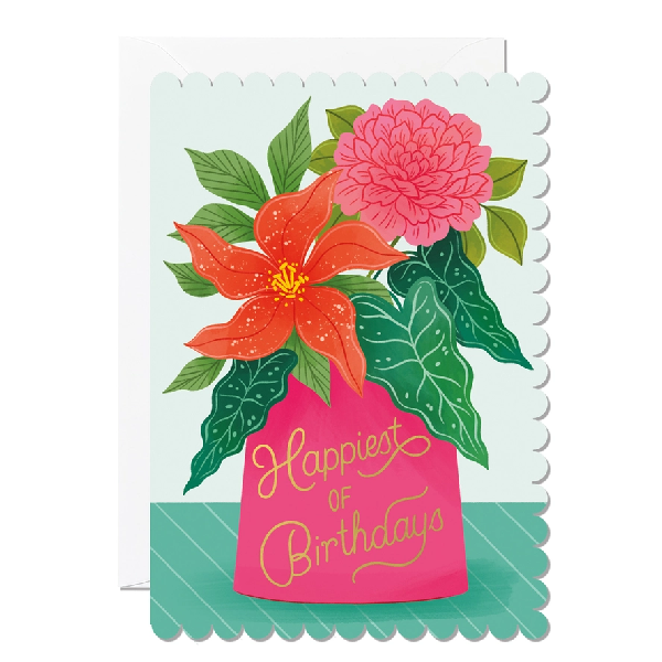 Greeting card with scalloped edges, featuring an illustration of red and pink flowers in a bright pink vase. The text on it reads "Happiest of Birthdays".