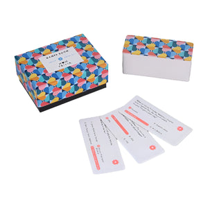 A colorful box of 'Mom Trivia' questions with a pattern of abstract heart shapes in various colors on the packaging. A deck of trivia cards sit beside the box.