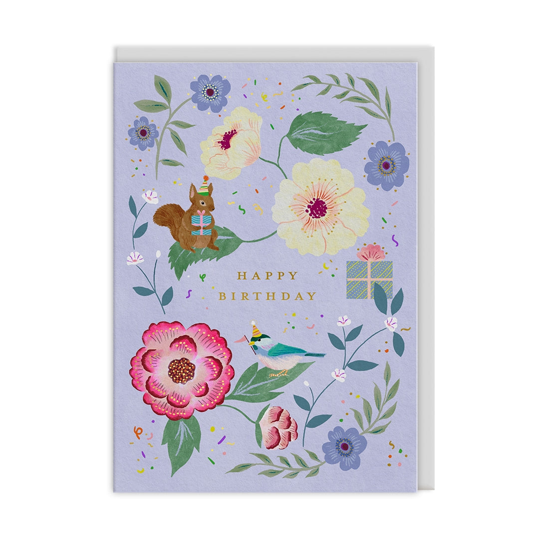 Greeting card with a floral and squirrel wearing a party hat illustration on a light purple background. The text "Happy Birthday" sits in the centre of the card. 
