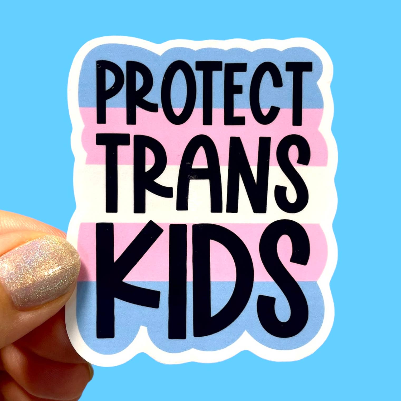 A sticker with the colours of the Trans Flag surrounded by a white border. The text 'Protect Trans Kids' is printed in black over the colours. 