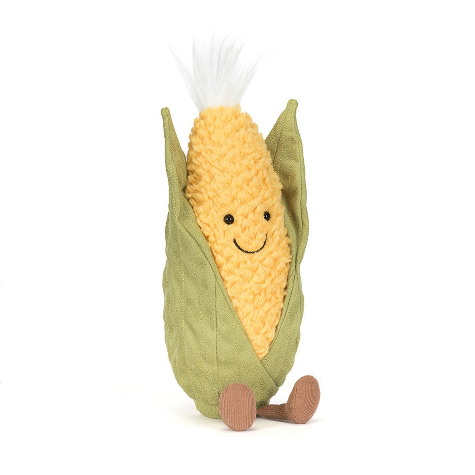 Front view of a Jellycat yellow and green corn on the cob shaped plush with a smiling face and a white tuft of hair on a white background