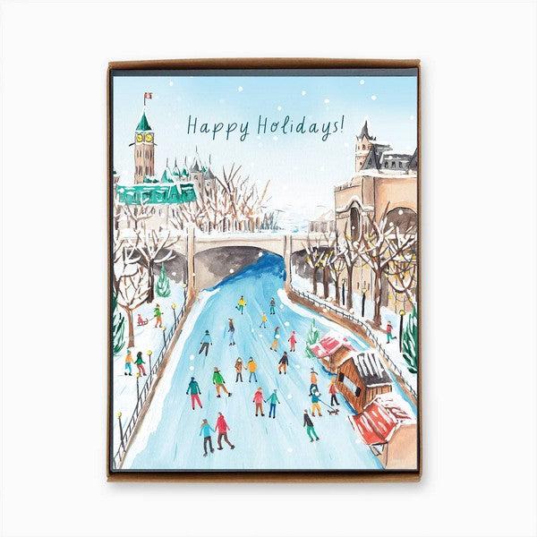A boxed Christmas card featuring the Rideau Canal in Ottawa with people skating and holiday decorations. The text 'Happy Holidays!' sits at the top of the card. 